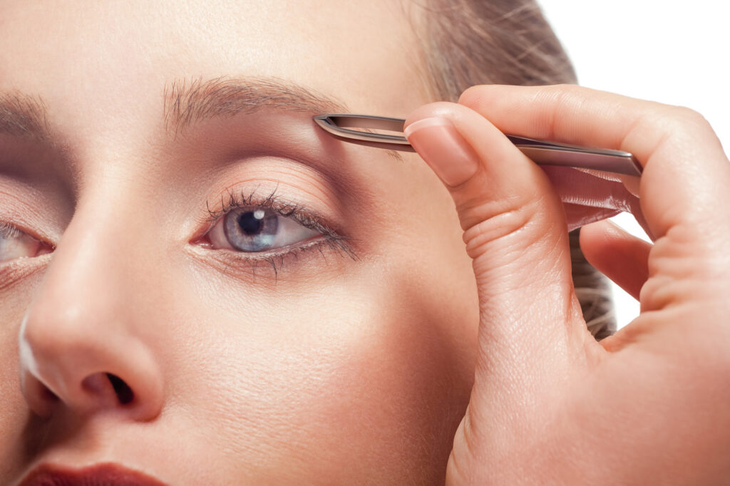Woman plucking eyebrows | 5 Eyebrow Shaping Tools | Beauty | Elle Blonde Luxury Lifestyle Destination Blog