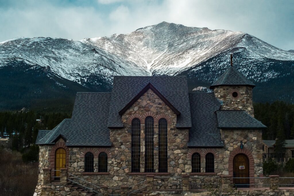 Monastry looking building in front of mountains  | Where to find mountain land for sale | Home Interiors | Elle Blonde Luxury Lifestyle Destination Blog