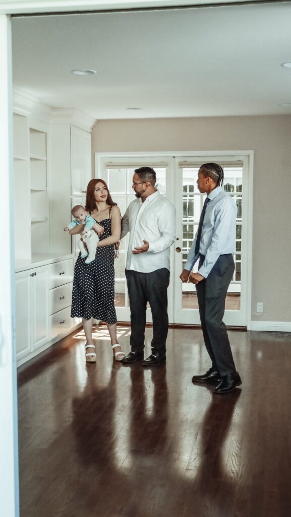 Couple with baby looking at hallway with realtors | Benefits of Using a Realtor | Home Interiors | Elle Blonde Luxury Lifestyle Destination Blog