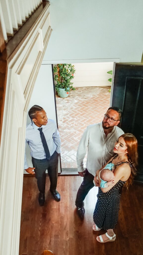 Couple with baby looking at hallway with realtor | Benefits of Using a Realtor | Home Interiors | Elle Blonde Luxury Lifestyle Destination Blog