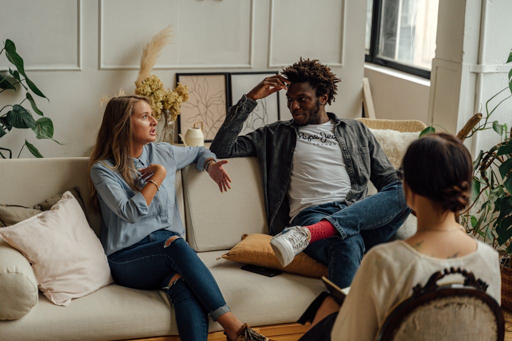 Sensate Focus: Cultivating Awareness for Pleasure and Intimacy | A couple is engaged in a lively conversation during a therapy session with a counselor. | elle blonde luxury lifestyle destination blog