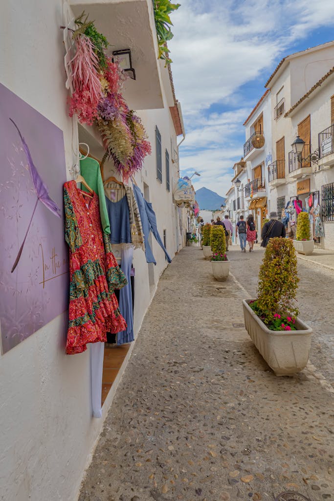 Best Things to Do in Altea, Alicante (Costa Blanca): A Slow Travel Itinerary 3 A vibrant street in Altea, Spain, showcasing colorful dresses and charming architecture.