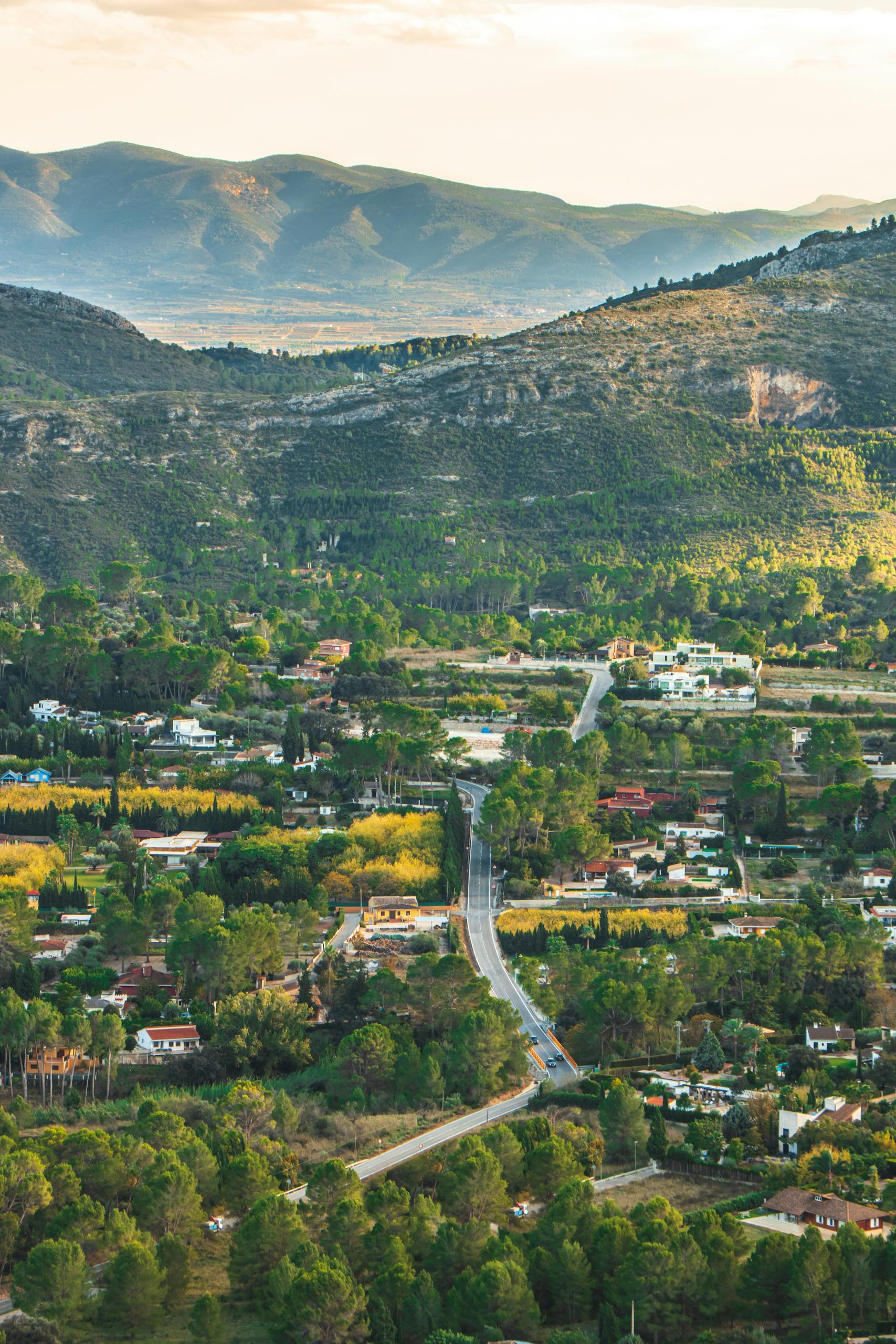 Aerial view of a picturesque town nestled in a vibrant green valley surrounded by mountains.