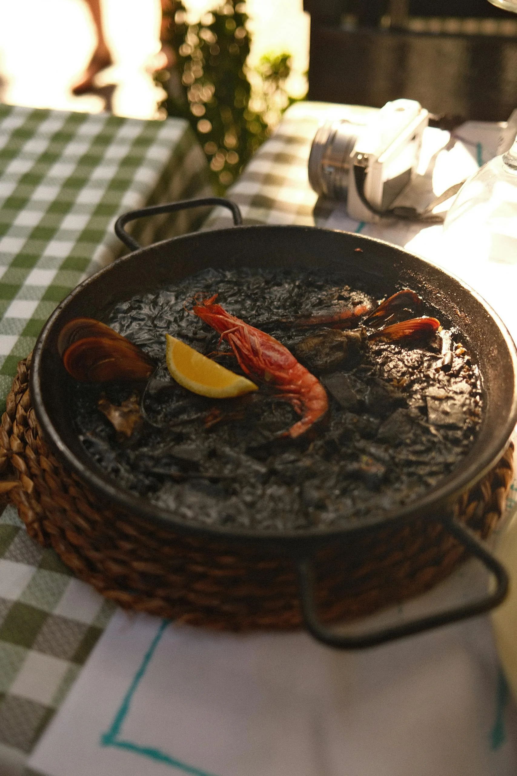 Close-up of a delicious seafood paella with shrimp and lemon on a wicker mat. Perfect for culinary themes. Fine dining in ibiza