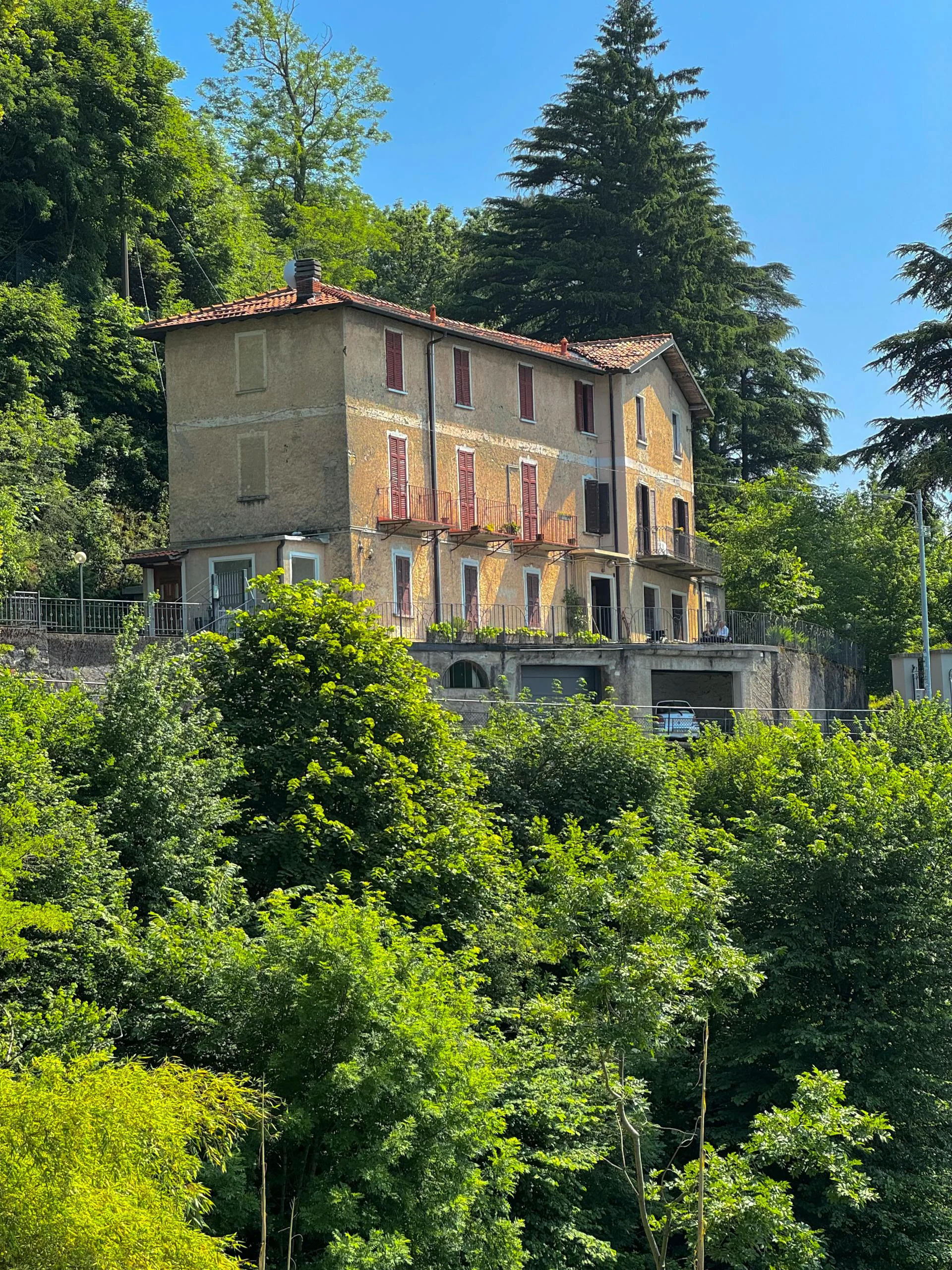 Picturesque Italian villa nestled amidst vibrant greenery, ideal for tourism imagery.