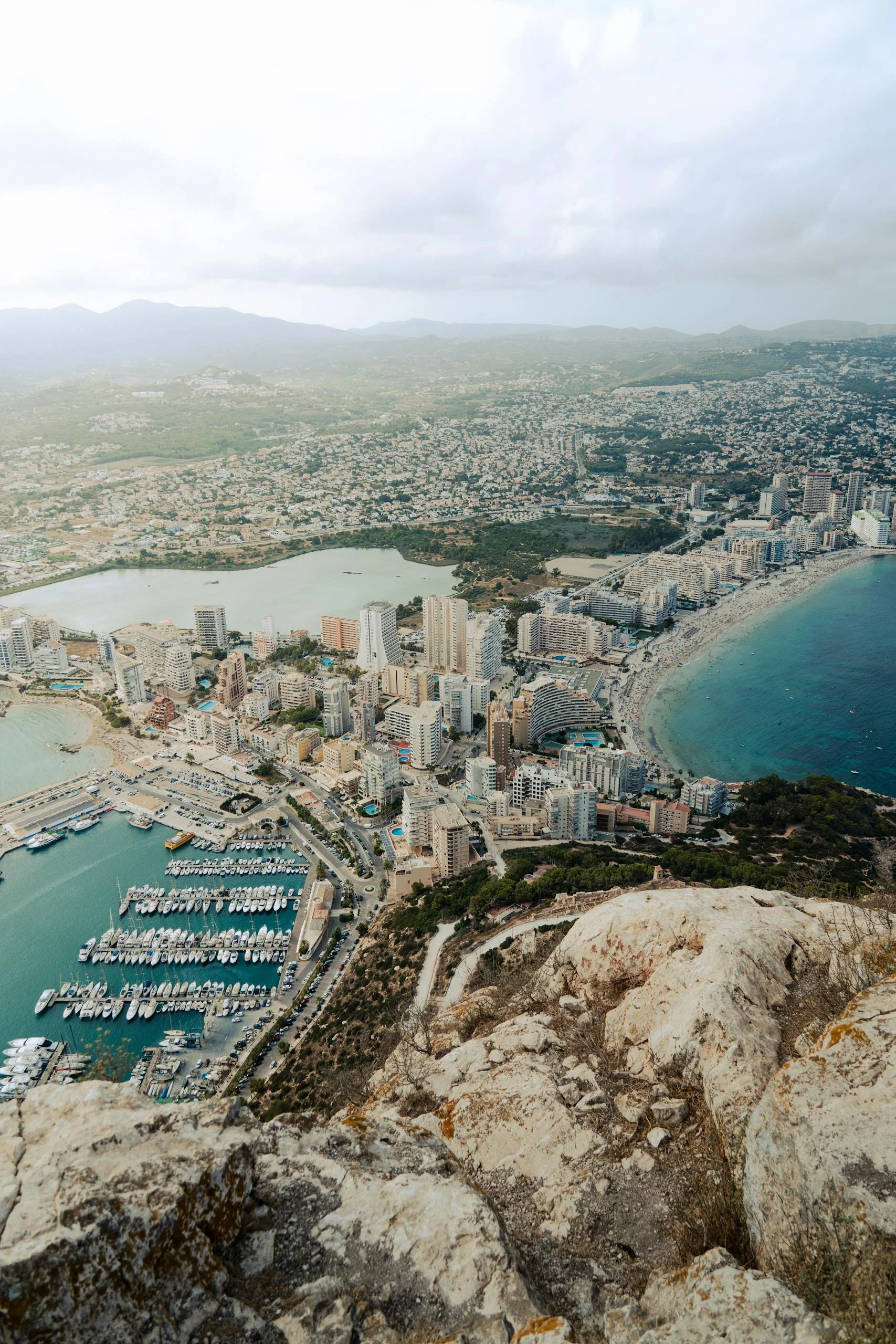 Stunning aerial shot of Calp's marina with towering skyscrapers and coastline.