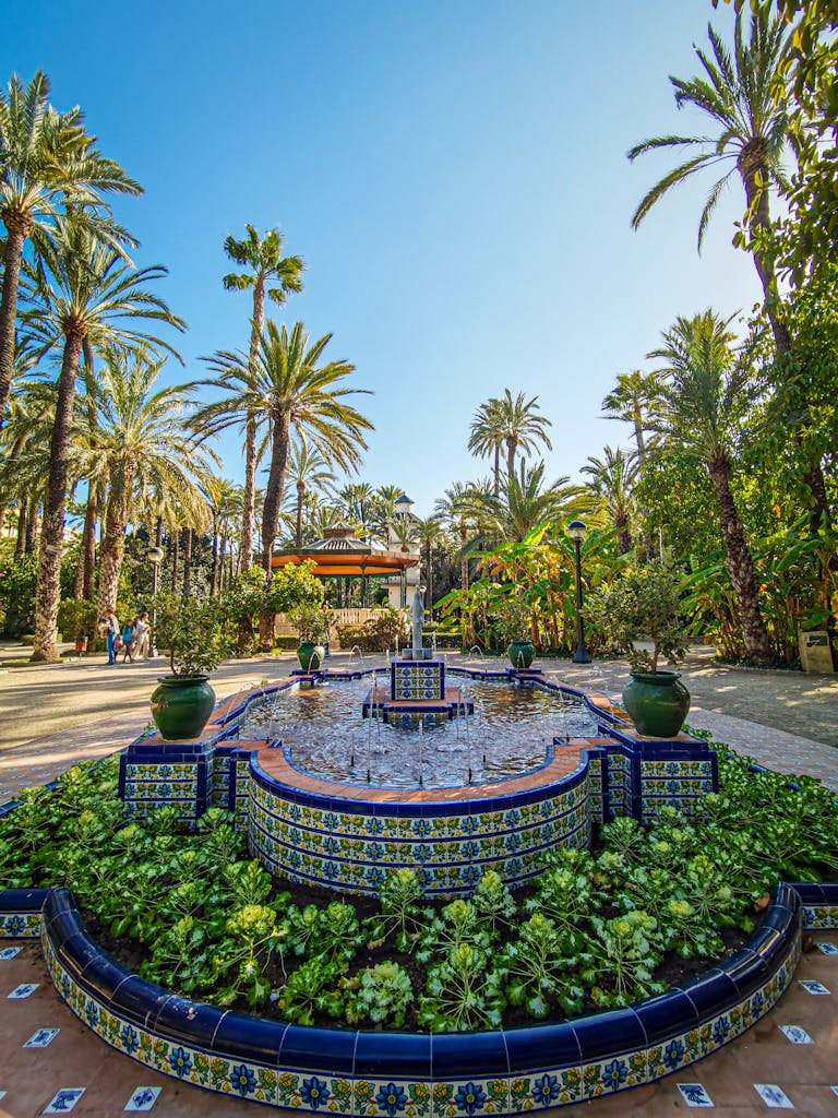 Beautiful fountain surrounded by palm trees in Elche's Palm Grove, Spain.