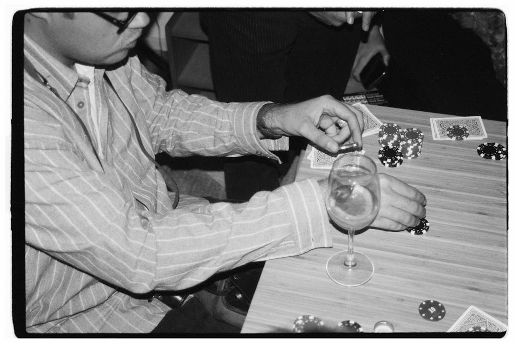 Classic black and white image of poker players with chips and cards on a table.