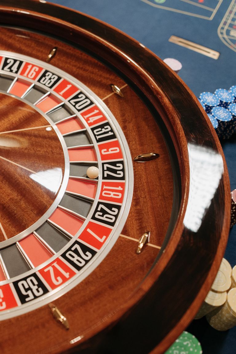Close-up of a roulette wheel with poker chips in a casino setting, highlighting chance and gambling. Sweepstakes