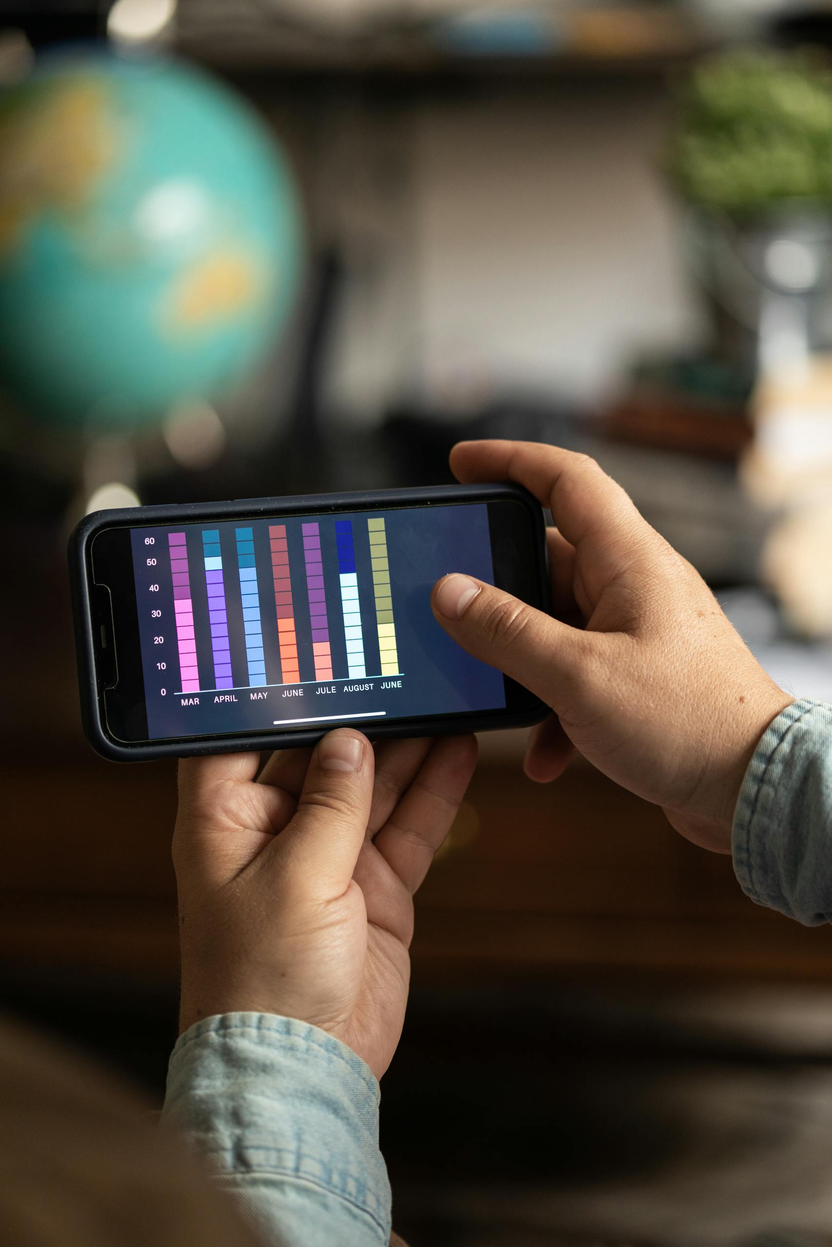 Business Intelligence Close-up of a smartphone displaying colorful data charts held by hands, showcasing digital analytics.
