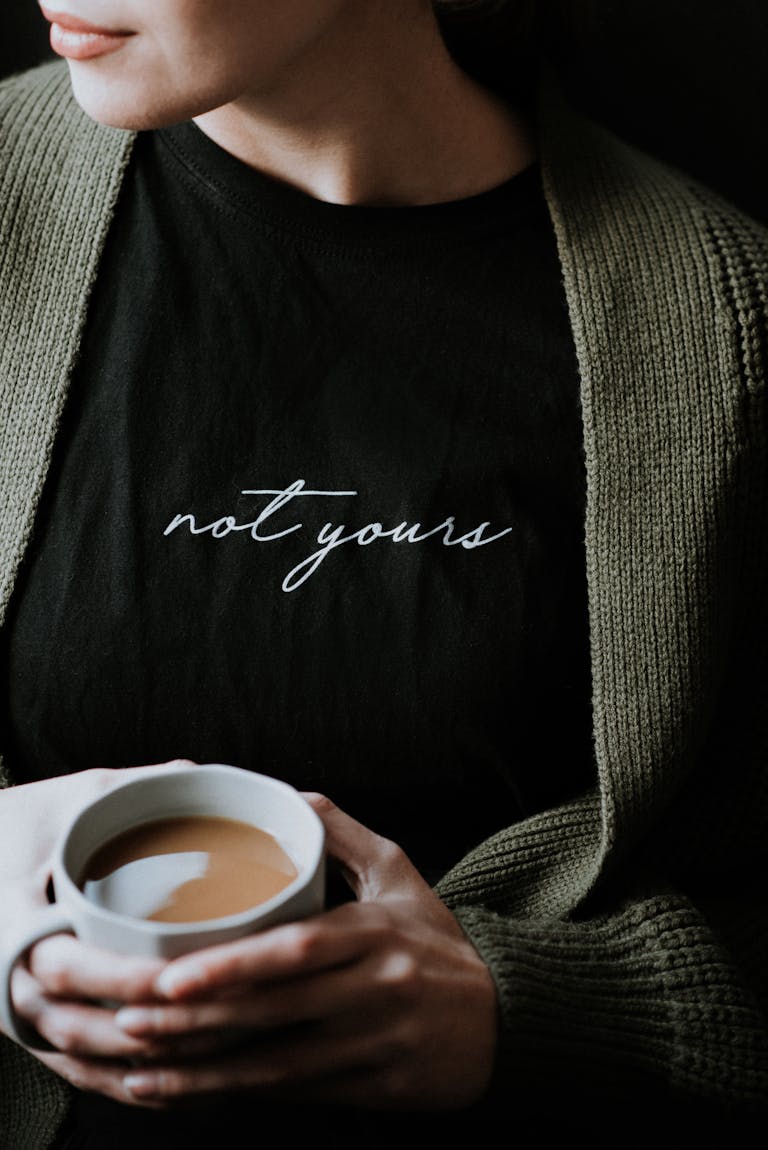 Cozy scene with a woman holding a cup of coffee, wearing a sweater.