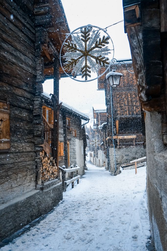 Explore the rustic charm of Grimentz village in winter, with wooden chalets covered in fresh snow.