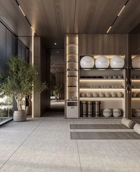 A high-end, minimalist yoga and pilates studio featuring neutral tones, rolled mats, sculptural fitness balls, and built-in shelving, designed for calm and elegance. | Reformer Pilates & Healthy Wellbeing | Elle Blonde Luxury Lifestyle Destination Blog