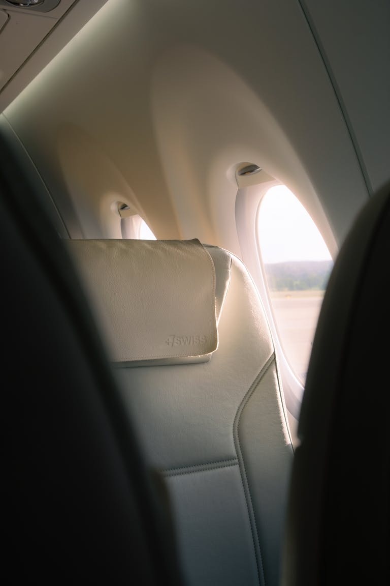 9 First Class Packing Secrets That Work in Economy Peaceful airplane interior with sunlight through window, ideal for travel visuals.