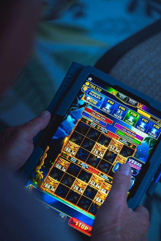 Person playing a mobile gaming app on a tablet, focused on fun and entertainment. Swedish Online Casinos