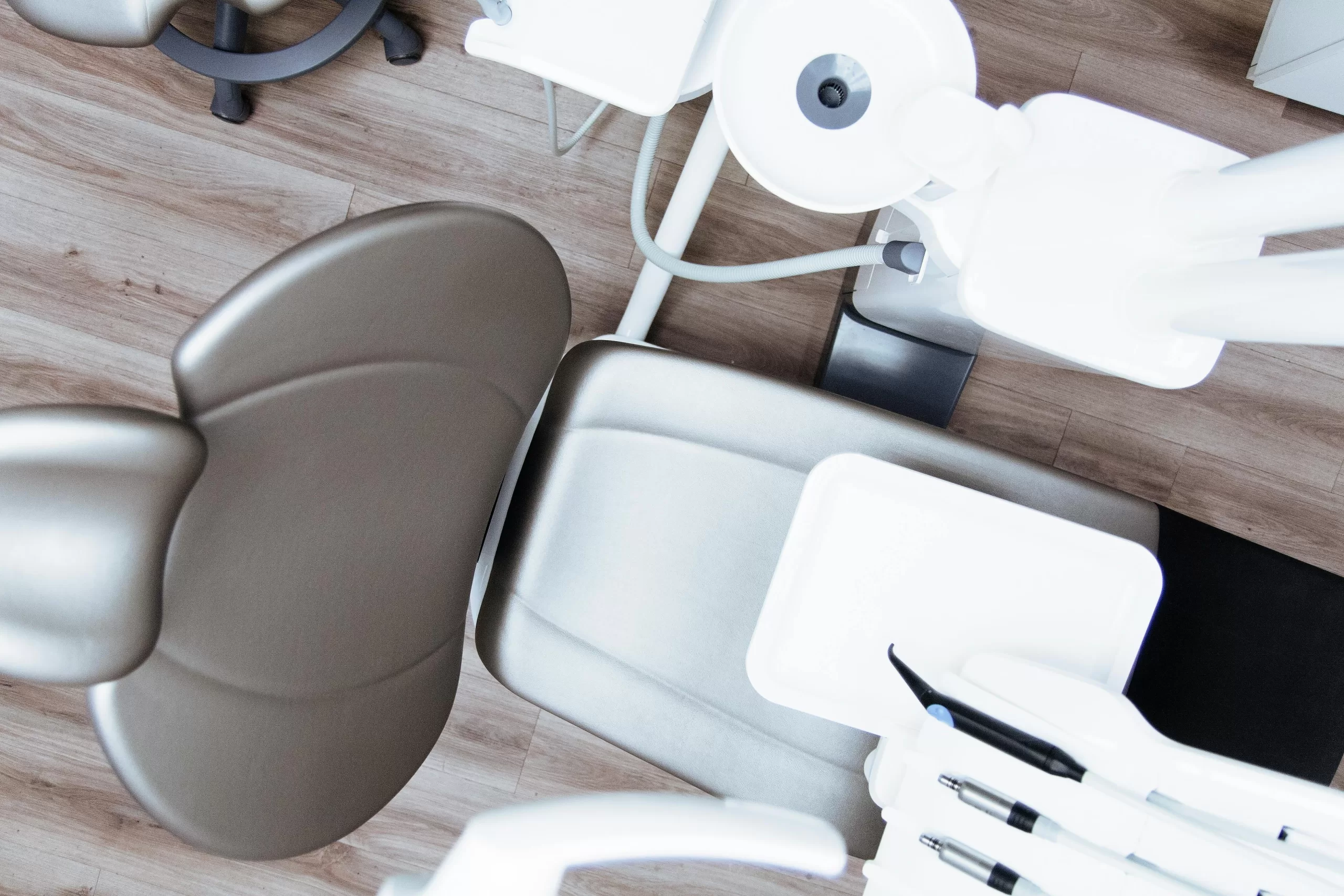 A dentist performs a procedure using modern dental equipment on a patient wearing protective glasses. | 8 Different Types of Dental Services For the Best Teeth | elle blonde curated luxury for the women making money online