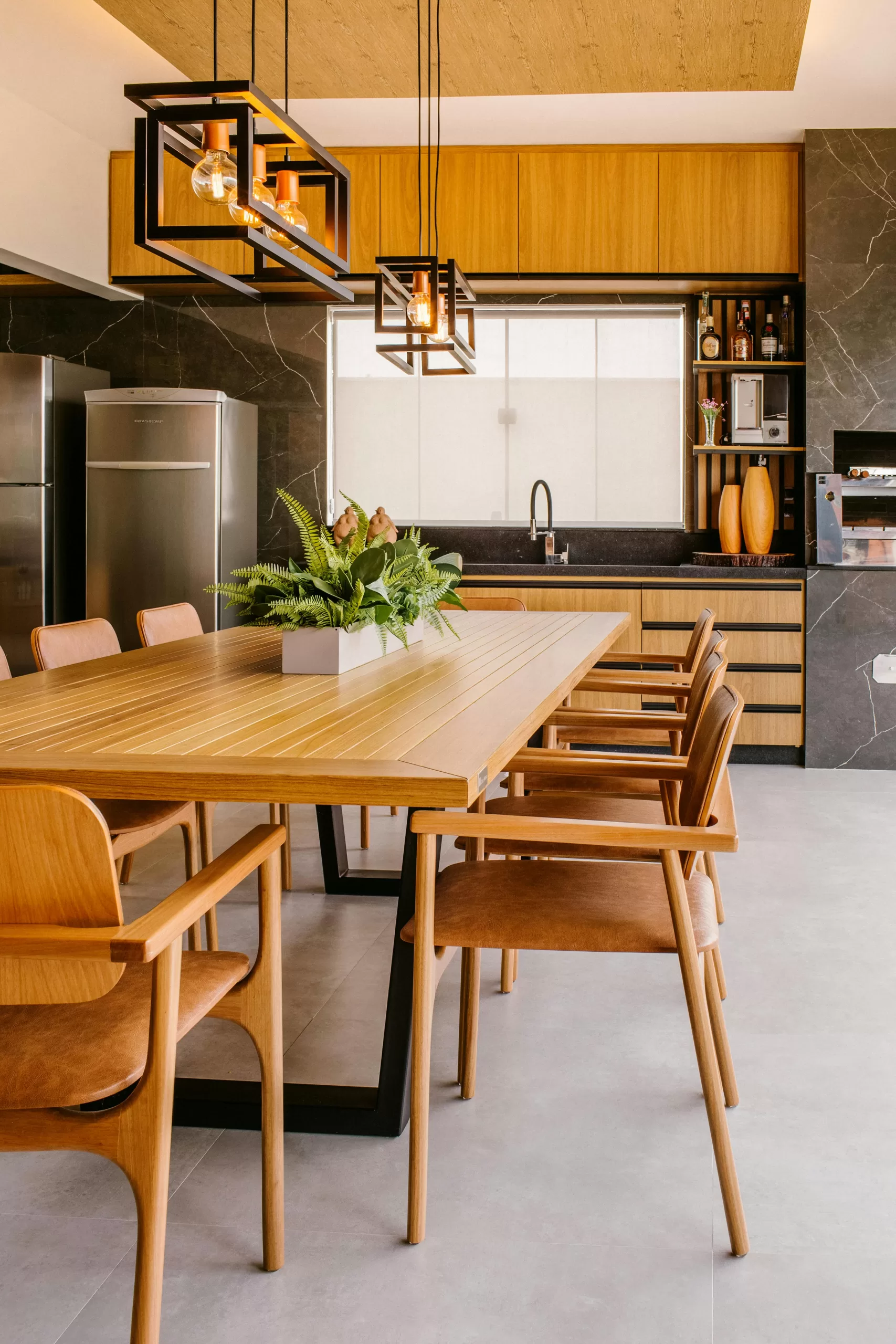 A contemporary luxury kitchen and dining space featuring sleek wood cabinetry, minimalist pendant lighting, and a modern dining table set for six — capturing the refined elegance of a high-end vacation villa or upscale serviced apartment. | How to Prepare for a Kitchen Extension in Your Renovation | Home Interiors | Elle Blonde Luxury Lifestyle Destination Blog