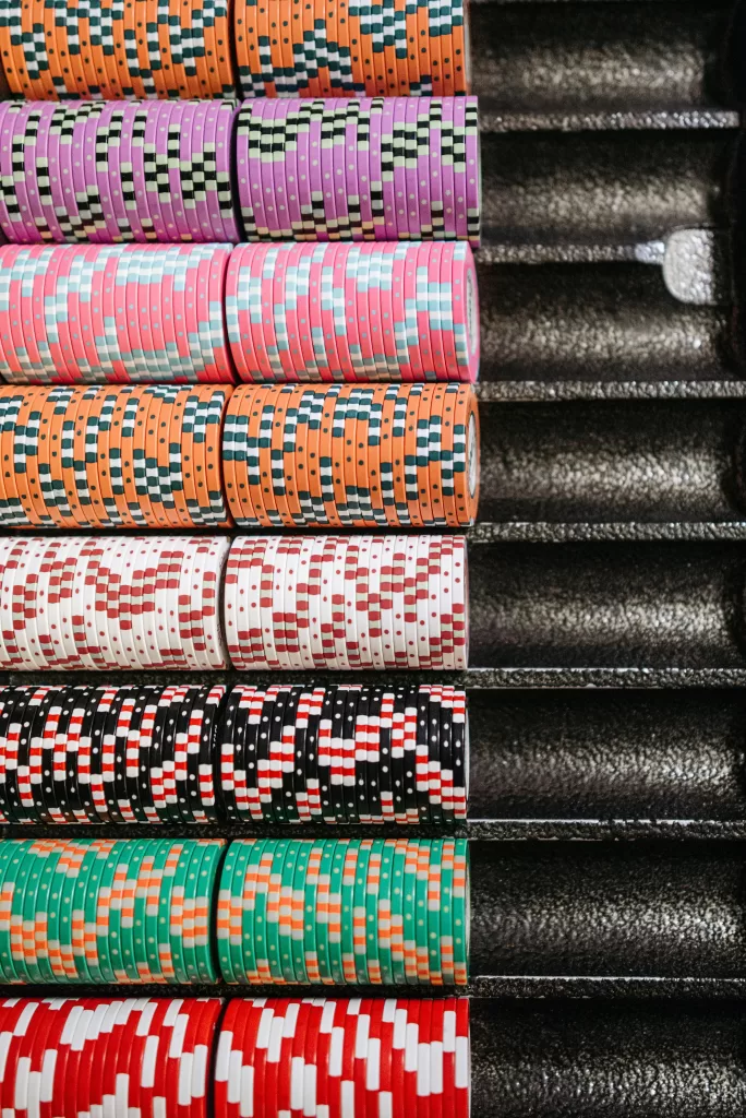 How to Gamble Smart and Stylishly 2 A vibrant, colour-coordinated display of poker chips neatly stacked in a casino chip tray, symbolising the allure of high-stakes play. | How to Gamble Smart and Stylishly | Elle Blonde Luxury Lifestyle Destination Blog