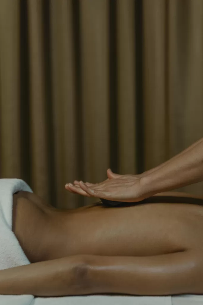 How to Make Business Travel Feel Like a Relaxing Getaway 7 A serene spa moment showing a hand mid-massage on a relaxed back, capturing the essence of self-care, calm, and luxury wellness. | Travel Tips | Elle Blonde Luxury Lifestyle Destination Blog