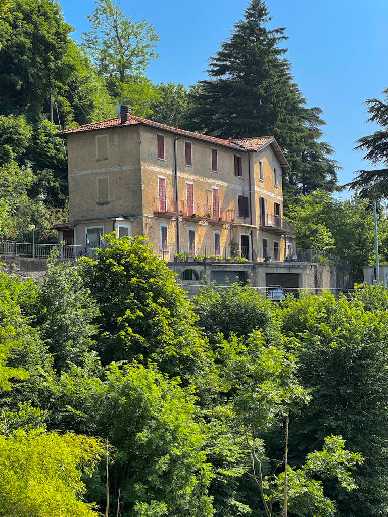 Picturesque Italian villa nestled amidst vibrant greenery, ideal for tourism imagery.