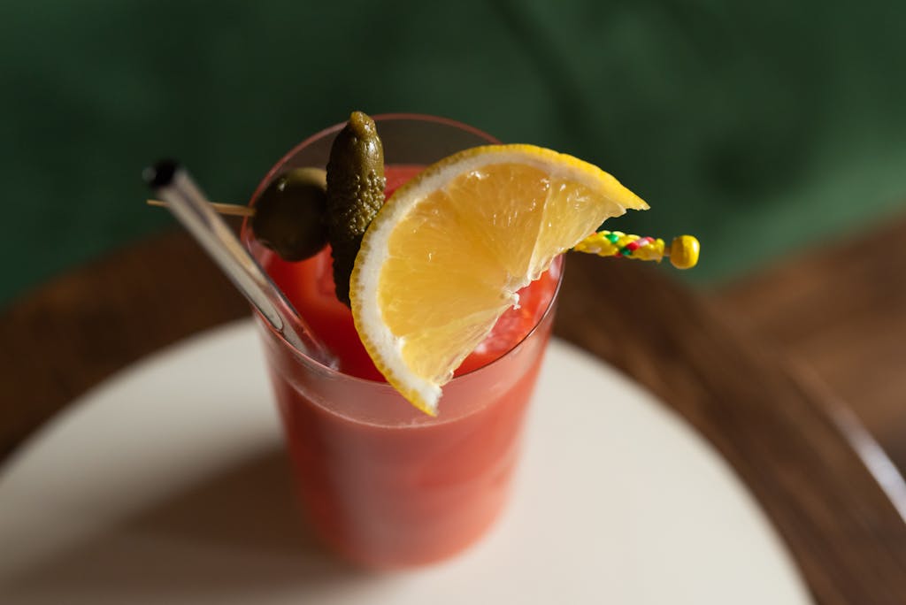The Art of the Garnish: Elevating Your Home Bar with Sophisticated Floral and Fruit Accents 3 Stylish red cocktail served with lemon slice, pickles, and glass straw. Perfect for summer refreshment. The Art of the Garnish: Elevating Your Home Bar with Sophisticated Floral and Fruit Accents