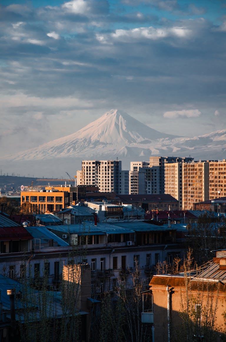 Urban skyline with prominent mountain backdrop during dusk, illustrating a blend of city and nature.